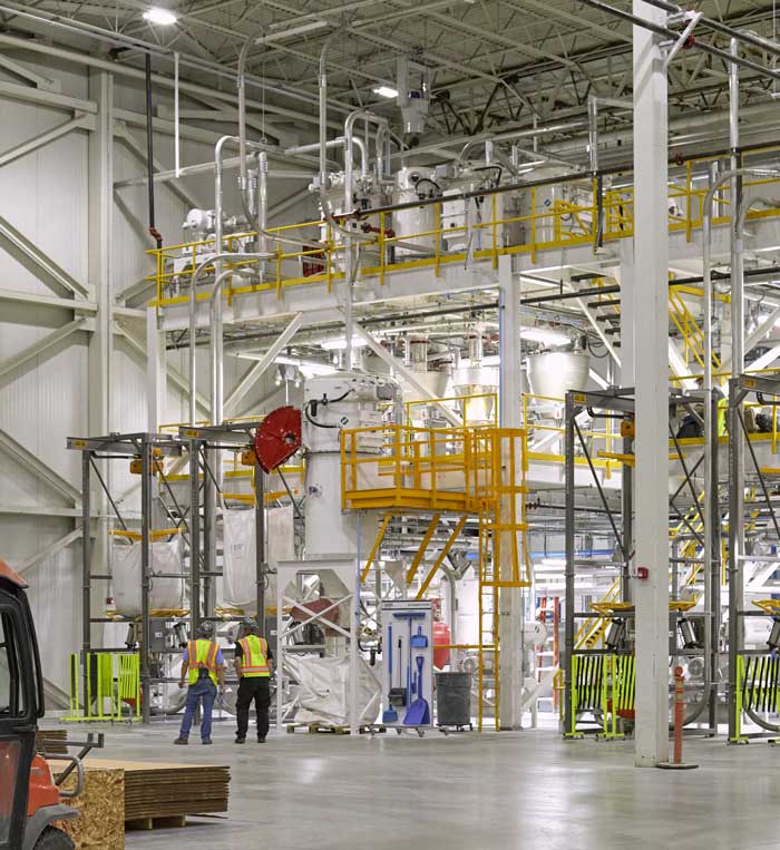 Two workers look at the AZEK Boise factory machines