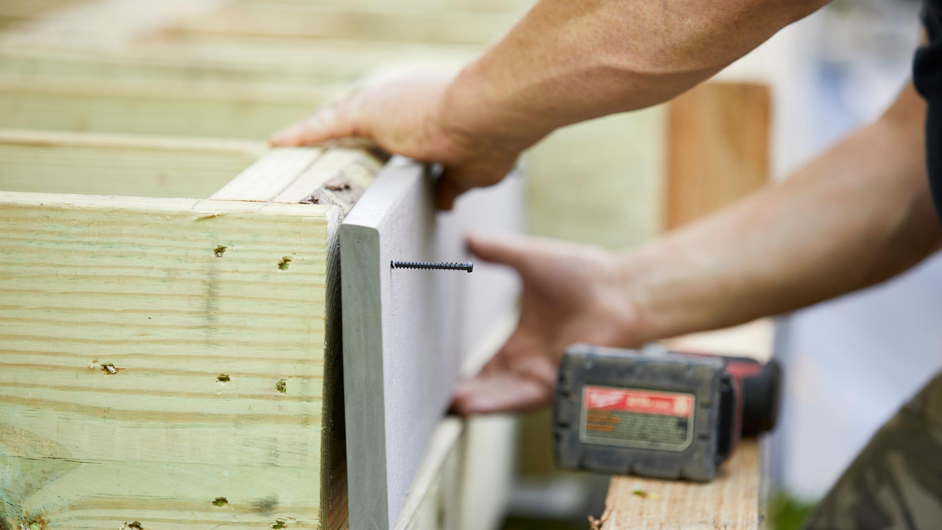 Contractor installing a fascia deck board