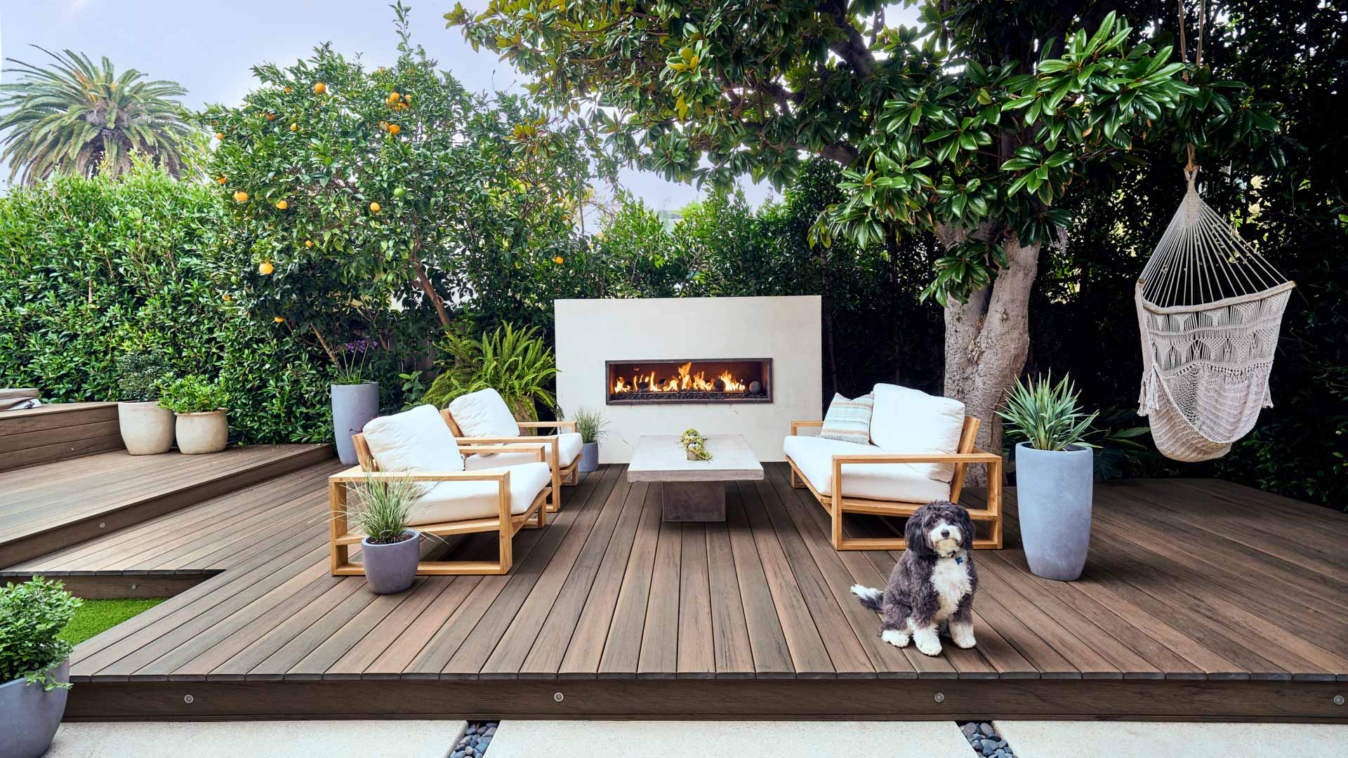 A patio with pecan decking and a outdoor fireplace decorated with white stucco. This image appeared in Sunset Magazine. Read more details by clicking 'View Story' below. 