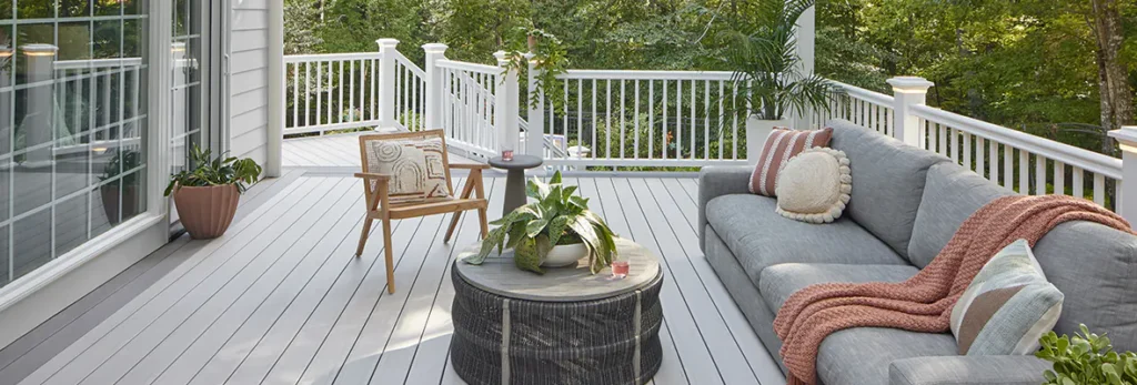 Gray wraparound TimberTech deck on the side of a home with outdoor living room furniture.