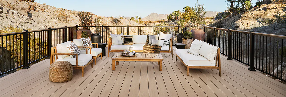 Photo of a light tan deck in the Palm Desert of California. The deck extends over a rocky, sandy area with mountains in the background.