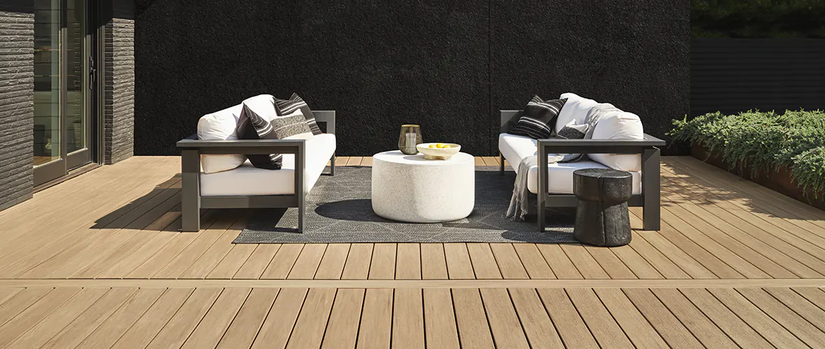 The contrast of a light brown deck with black and white outdoor living room on top of it creates a modern look and feel to the space.