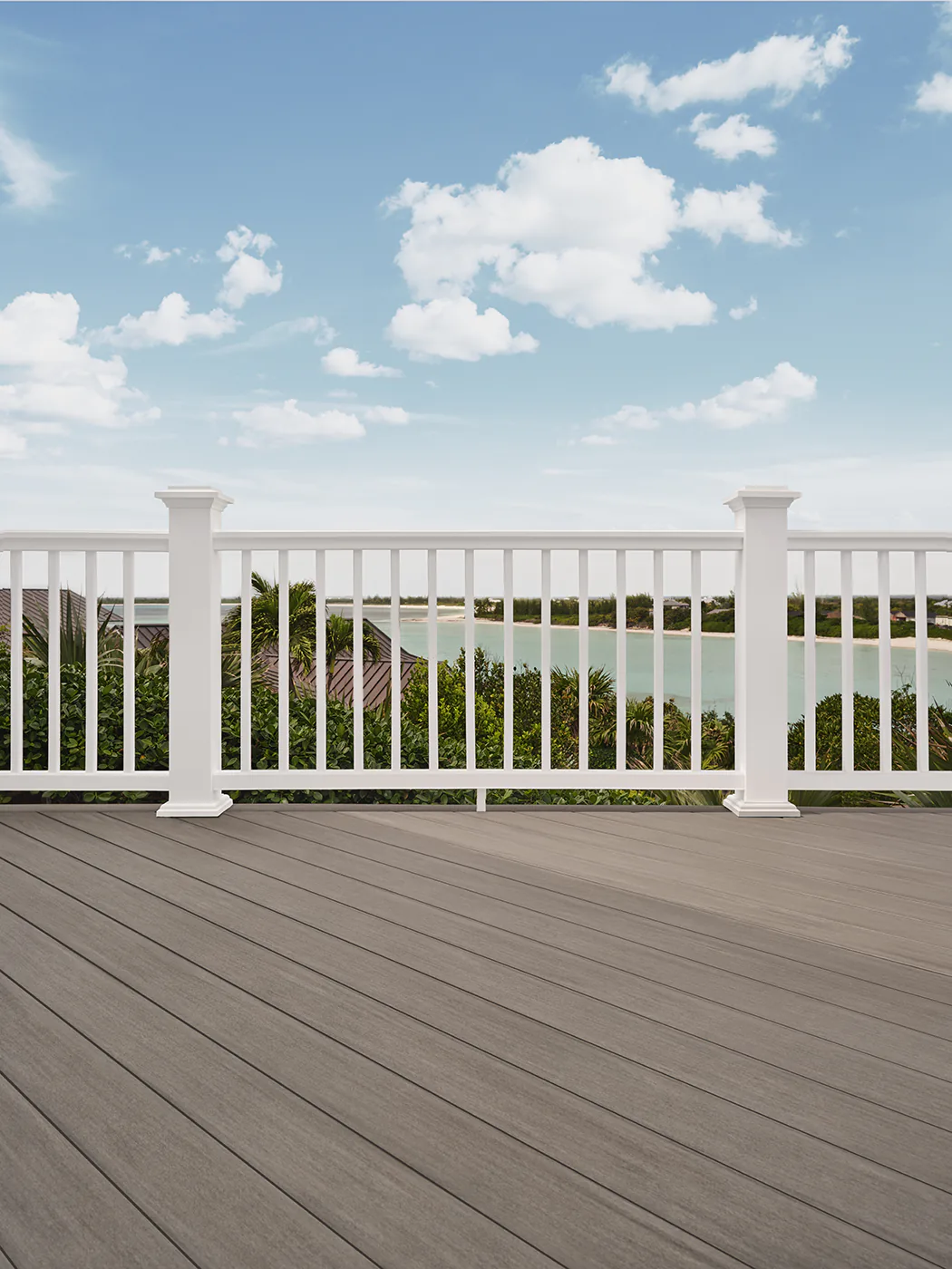 White railing with a view of the bay visible between the bold white vertical balusters.