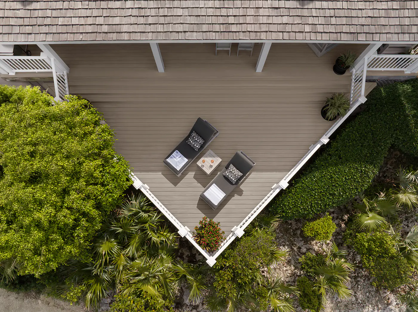 Aerial view of Darren's deck showing two lounge chairs with a side table and drinks between them. The deck comes to a point as if it were a lookout spot where one could appreciate the view.