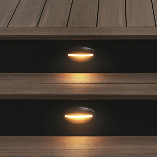 In-deck riser lights illuminate the walkways of a deck at night