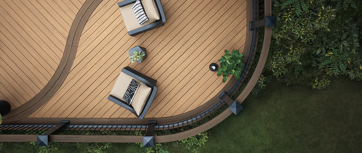 A curved deck with chairs, a table, and a grill. 