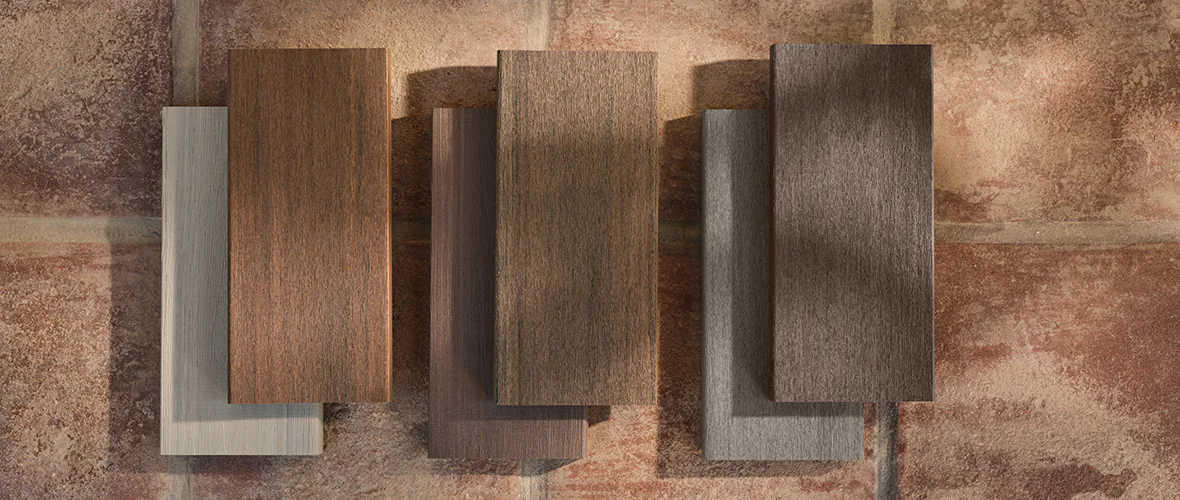 A group of wood samples on a brick wall.