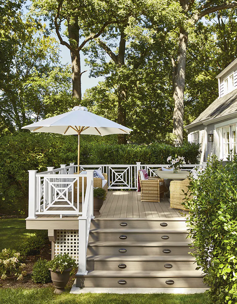 An umbrella and two distinct seating areas full of outdoor furniture dot the deck of Mary Kate