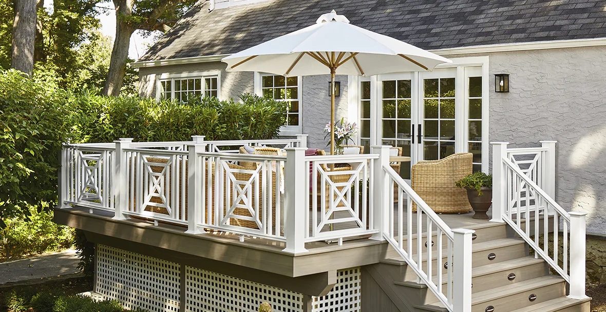 Mary Kate's cozy backyard deck with decorative white infill railing around the perimeter