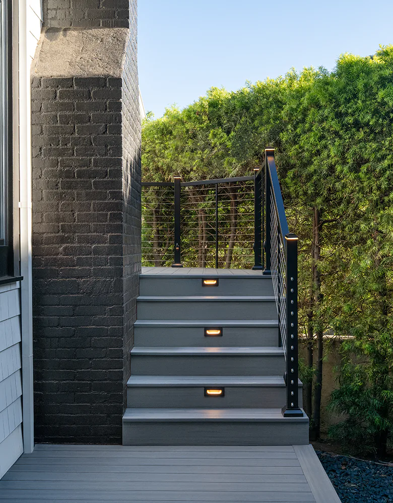 Deck stairs with wrap around railing lead to the elevated portion of Tony's deck.