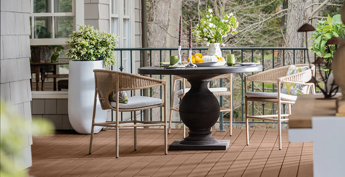 An outdoor table on the deck is set with candles and dishes as is to create an intimate place for two to dine.