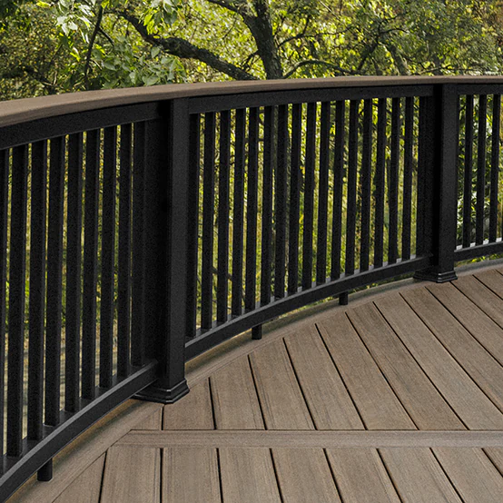 Black railing with a deck board used as the top rail that curves with the brown deck underneath