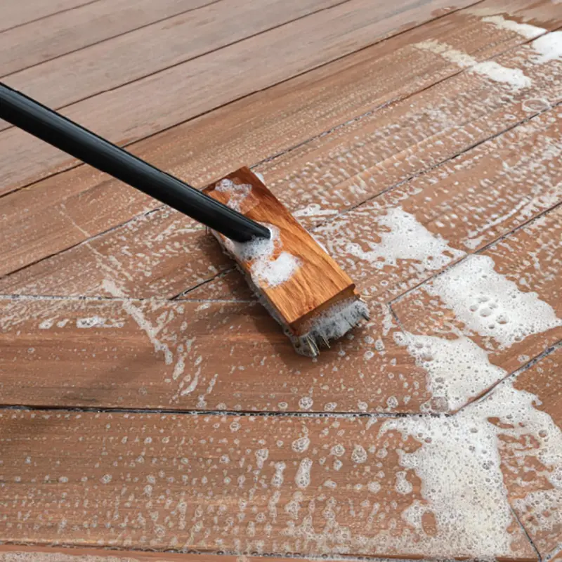 Scrub brush using TimberTech Deck Cleaner solution to wash a deck